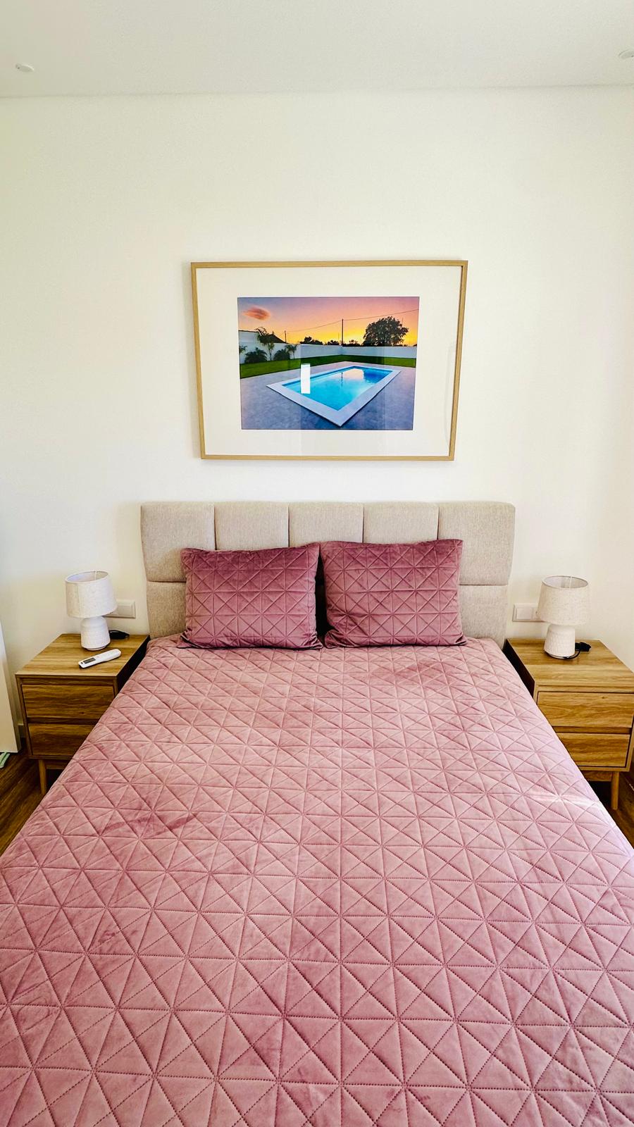 Quarto com cama de casal e mesas de cabeceira em madeira