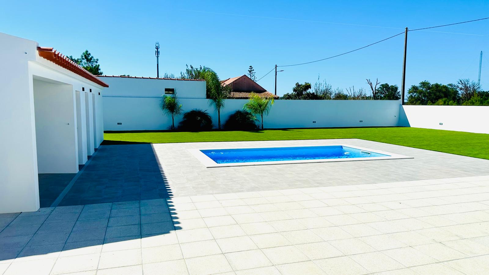 Piscina e relvado privativos num dia de sol