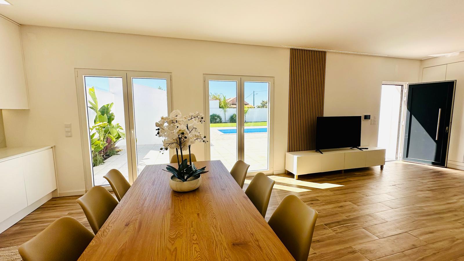 Mesa de refeições com vista para a sala e para a piscina