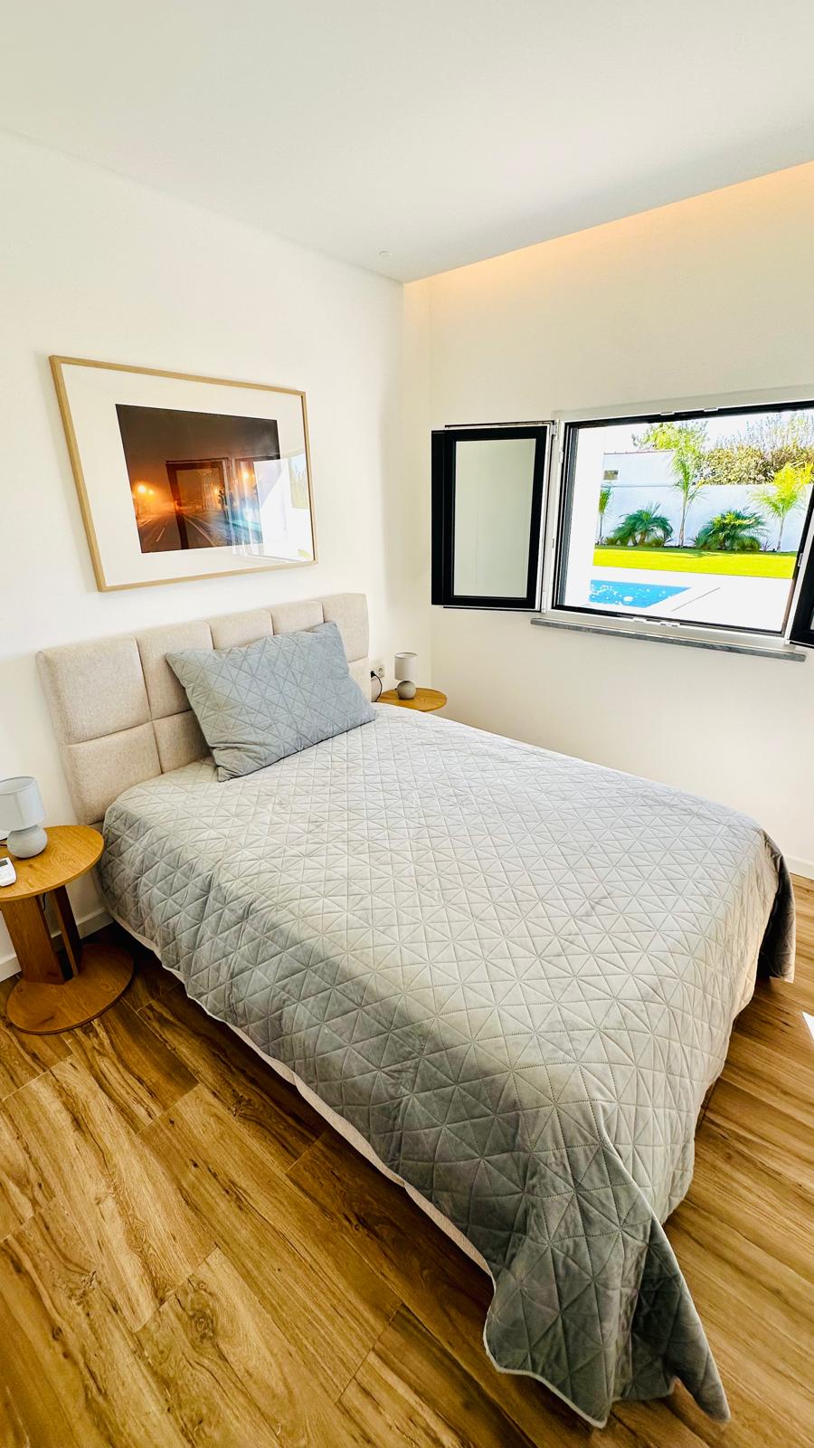 Quarto com cama individual e janela aberta para a piscina
